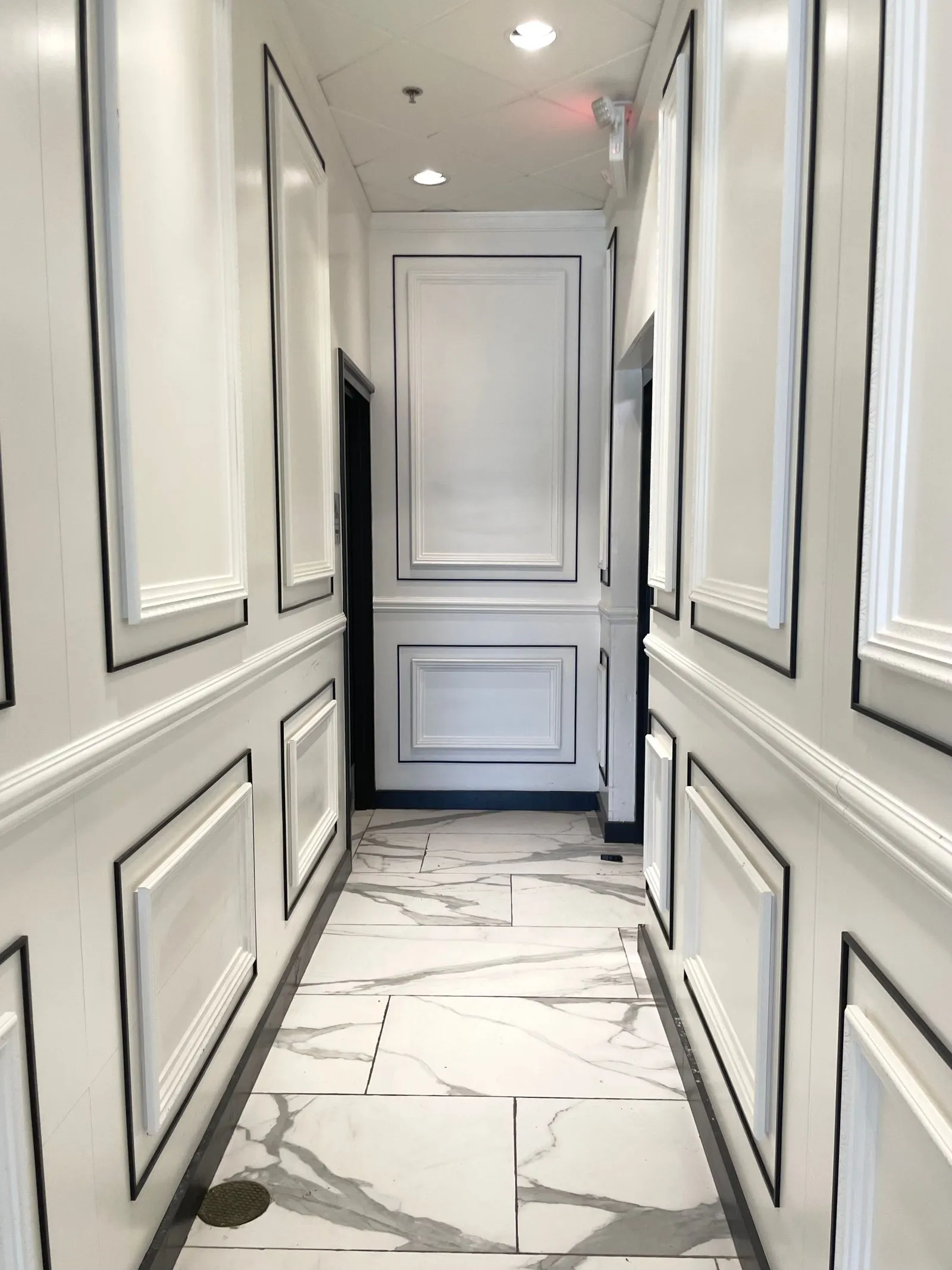 Corridoio con pavimento in marmo bianco venato lucidato